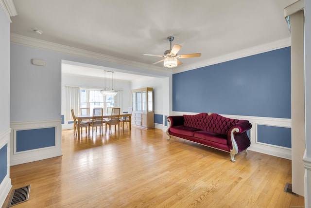 240 Highland Ave, Stratford, CT 06614 - living area with ceiling fan, light wood-style flooring, wainscoting, and ornamental molding