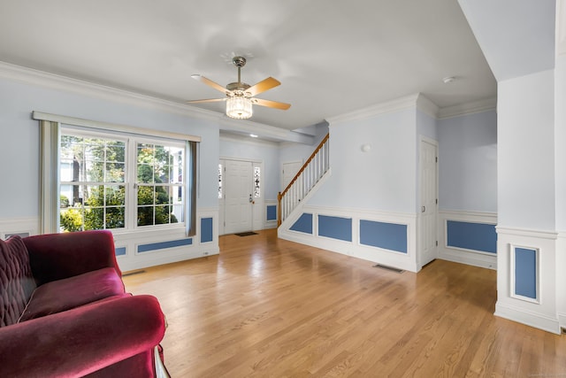 240 Highland Ave, Stratford, CT 06614 - living area with a ceiling fan, wood finished floors, wainscoting, crown molding, and stairs