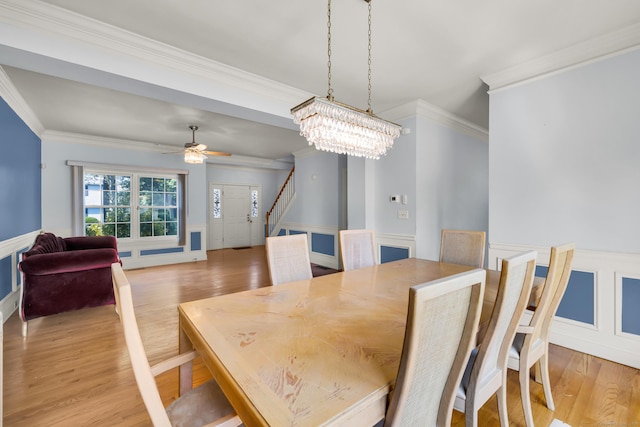240 Highland Ave, Stratford, CT 06614 - dining space featuring a decorative wall, wood finished floors, crown molding, wainscoting, and a chandelier