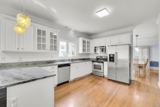 240 Highland Ave, Stratford, CT 06614 - kitchen featuring appliances with stainless steel finishes, light wood finished floors, white cabinets, decorative light fixtures, and crown molding