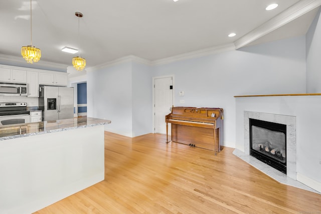 240 Highland Ave, Stratford, CT 06614 - kitchen with stainless steel appliances, crown molding, white cabinetry, light wood-type flooring, and light stone counters