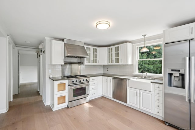 37 Cedar Crest Pl, Norwalk, CT 06854 - kitchen with stainless steel appliances, wall chimney exhaust hood, decorative backsplash, and light wood-style flooring