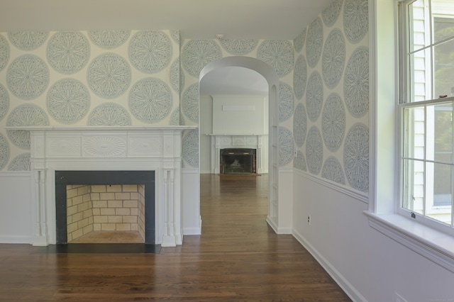 563 Main St, Ridgefield, CT 06877 - unfurnished living room with a fireplace, wallpapered walls, wood finished floors, arched walkways, and baseboards