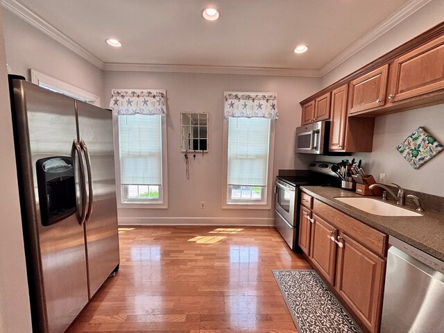 401 Cambridge Commons Unit 401, Middletown, CT 06457 - kitchen with appliances with stainless steel finishes, ornamental molding, brown cabinetry, dark countertops, and light wood-style floors