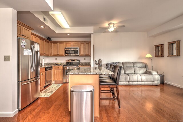 510 First Ave Unit 306, West Haven, CT 06516 - kitchen with appliances with stainless steel finishes, a kitchen bar, ceiling fan, open floor plan, and dark wood-type flooring