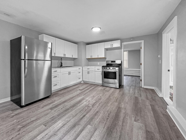 38 Hammond St, Vernon, CT 06066 - kitchen featuring appliances with stainless steel finishes, light wood finished floors, and white cabinetry