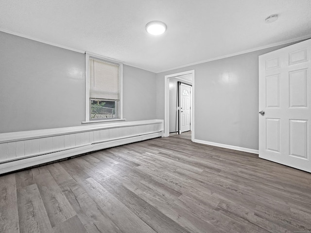 38 Hammond St, Vernon, CT 06066 - spare room featuring a baseboard heating unit, wood finished floors, ornamental molding, and a smoke detector