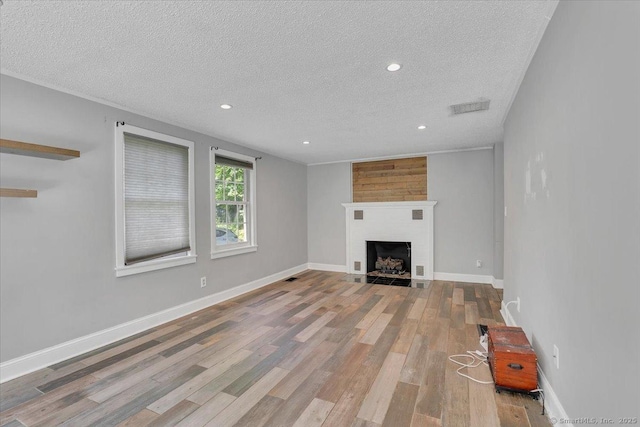 57 Whitney Rd, Columbia, CT 06237 - unfurnished living room featuring a textured ceiling, recessed lighting, wood finished floors, and a large fireplace
