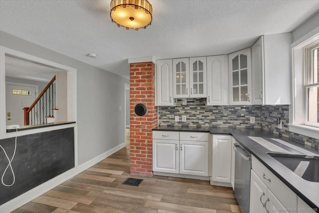 57 Whitney Rd, Columbia, CT 06237 - kitchen with stainless steel dishwasher, dark countertops, glass insert cabinets, decorative backsplash, and a textured ceiling
