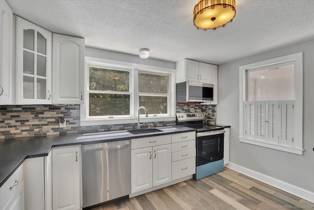 57 Whitney Rd, Columbia, CT 06237 - kitchen featuring appliances with stainless steel finishes, dark countertops, tasteful backsplash, light wood-style flooring, and a textured ceiling