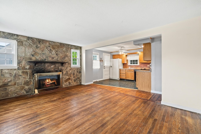 51 Goodwin St, Manchester, CT 06040 - unfurnished living room featuring a stone fireplace, dark wood-style floors, and a ceiling fan
