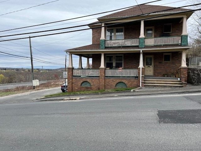 1085 Hamilton Ave, Waterbury, CT 06706 - view of front facade featuring a balcony, brick siding, and covered porch