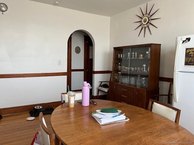 1085 Hamilton Ave, Waterbury, CT 06706 - dining room with arched walkways, wood finished floors, and baseboards