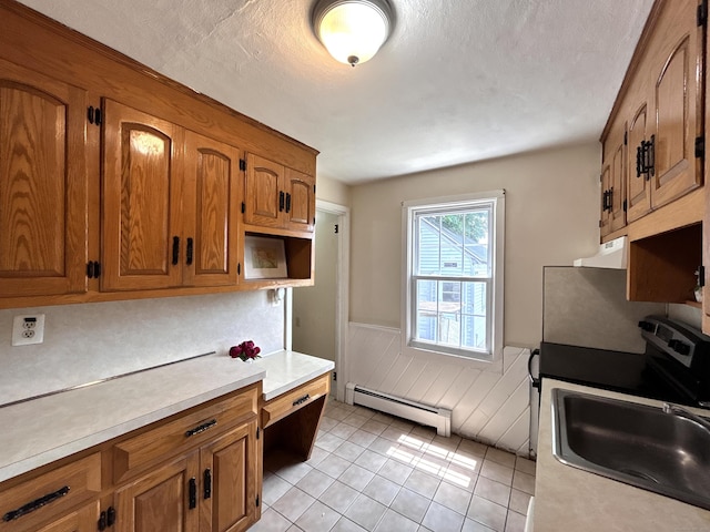 365 Ruth St, Bridgeport, CT 06606 - kitchen with a baseboard heating unit, brown cabinetry, a wainscoted wall, light countertops, and a textured ceiling