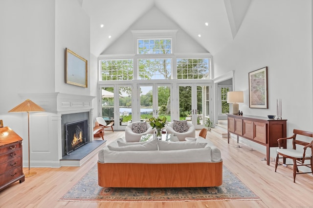 21 Oak Ridge Park, Westport, CT 06880 - living area with high vaulted ceiling, a lit fireplace, light wood-type flooring, french doors, and recessed lighting