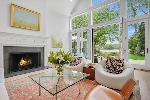 21 Oak Ridge Park, Westport, CT 06880 - living room featuring french doors, high vaulted ceiling, wood finished floors, a lit fireplace, and a water view