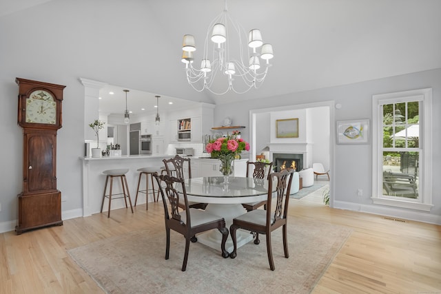 21 Oak Ridge Park, Westport, CT 06880 - dining room featuring light wood-style floors, a lit fireplace, high vaulted ceiling, and a chandelier