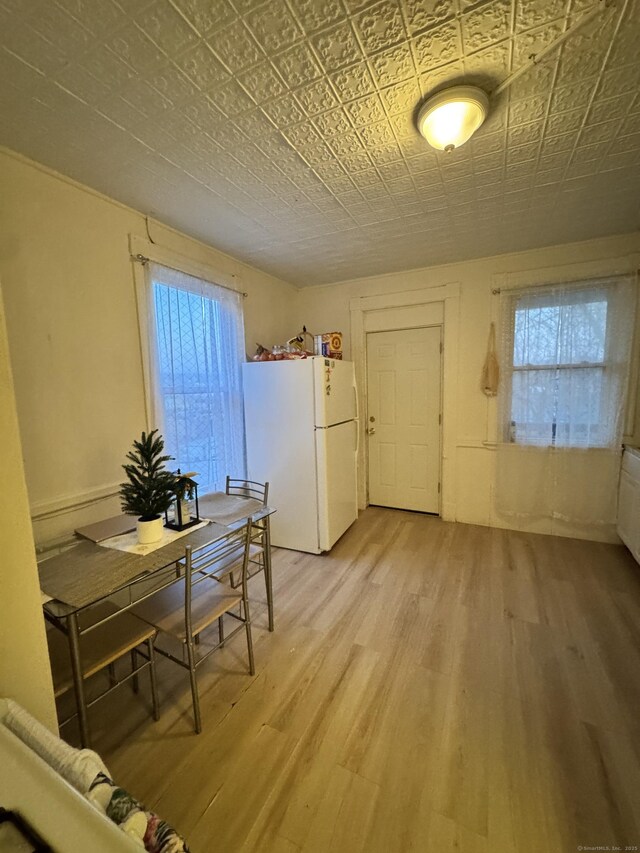 203 S Leonard St, Waterbury, CT 06708 - dining area with light wood-style flooring, plenty of natural light, and an ornate ceiling