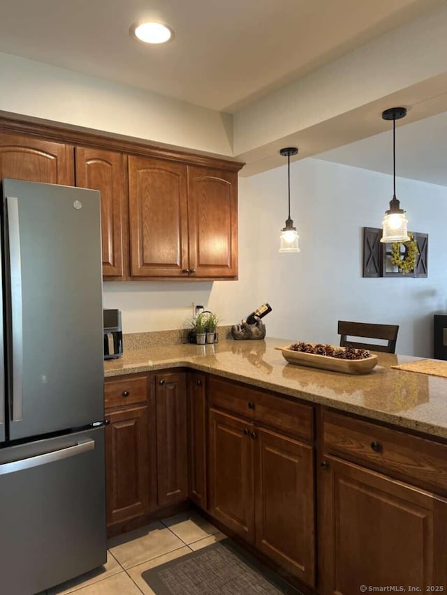 330 Crystal Ave Unit 20, New London, CT 06320 - kitchen with freestanding refrigerator, light tile patterned flooring, light stone counters, decorative light fixtures, and a peninsula