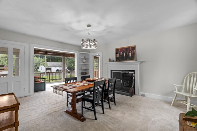 122 College St, Old Saybrook, CT 06475 - dining room featuring a fireplace with flush hearth, carpet flooring, and a chandelier
