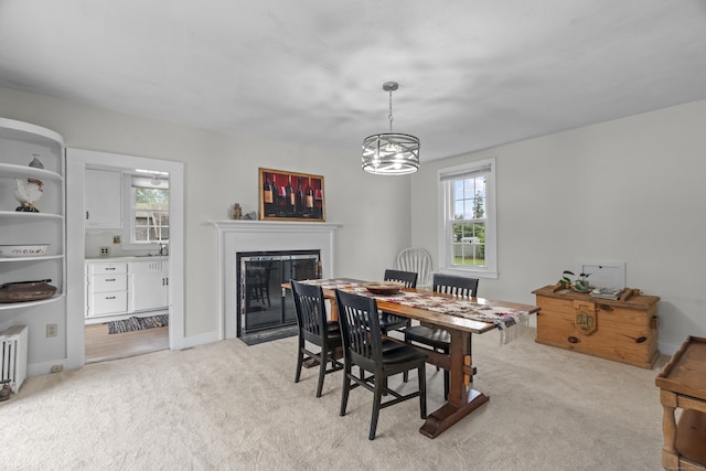 122 College St, Old Saybrook, CT 06475 - dining space featuring plenty of natural light, a fireplace with flush hearth, light carpet, and a chandelier