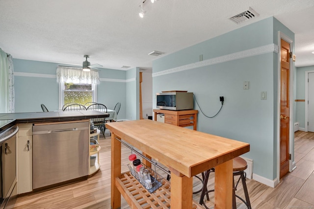 133 Savage Hill Rd, Berlin, CT 06037 - kitchen with stainless steel appliances, ceiling fan, tile counters, light wood-type flooring, and a textured ceiling