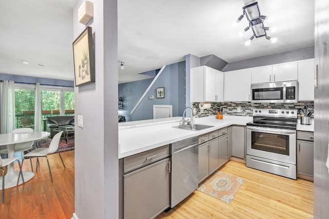 15 Perry Ave Unit D1, Norwalk, CT 06850 - kitchen featuring appliances with stainless steel finishes, light wood finished floors, decorative backsplash, light countertops, and gray cabinets