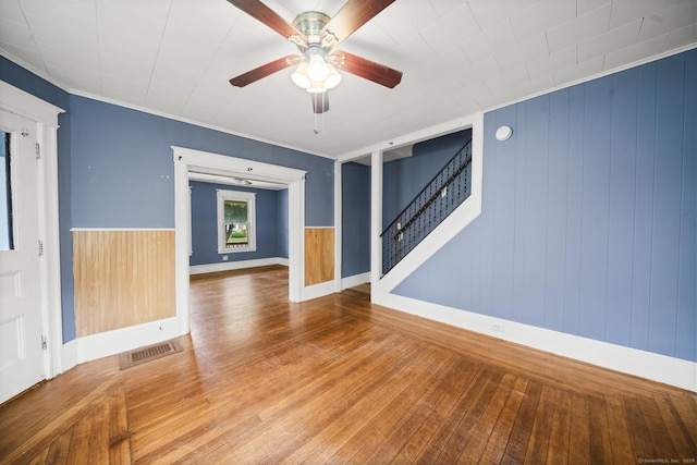 692 Enfield St, Enfield, CT 06082 - empty room featuring stairs, a ceiling fan, hardwood / wood-style floors, and wooden walls