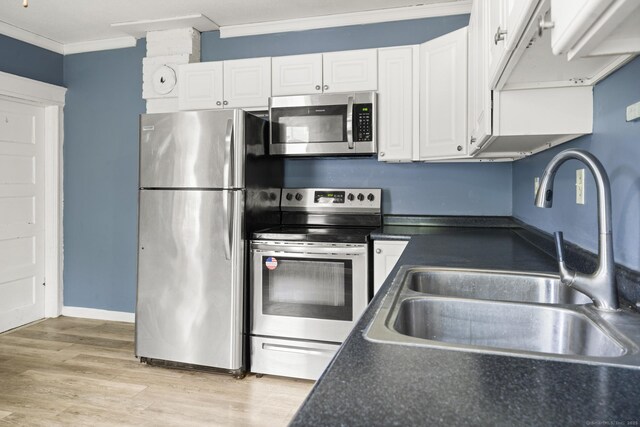 692 Enfield St, Enfield, CT 06082 - kitchen with appliances with stainless steel finishes, crown molding, dark countertops, and white cabinets
