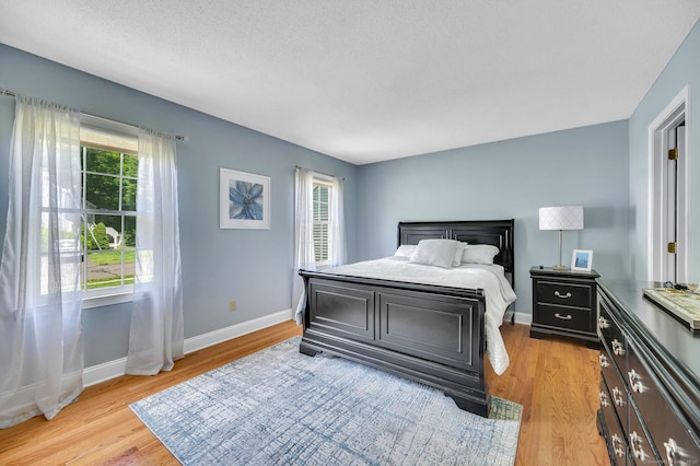 80 Quarry Village Rd, Cheshire, CT 06410 - bedroom with light wood-style floors, multiple windows, and a textured ceiling
