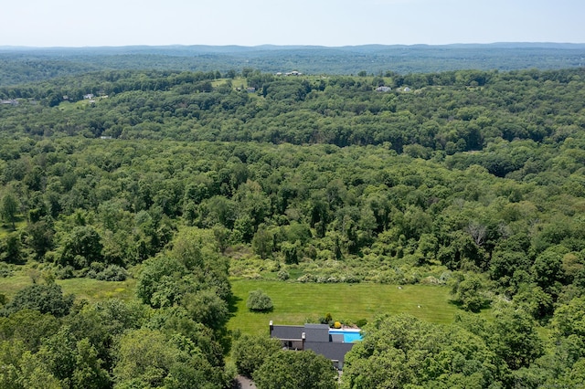 aerial view of property and surrounding area with a heavily wooded area