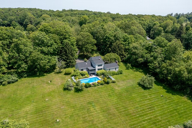 view of subject property featuring a pool area and a heavily wooded area