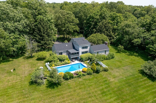 view from above of property with a pool area and a forest