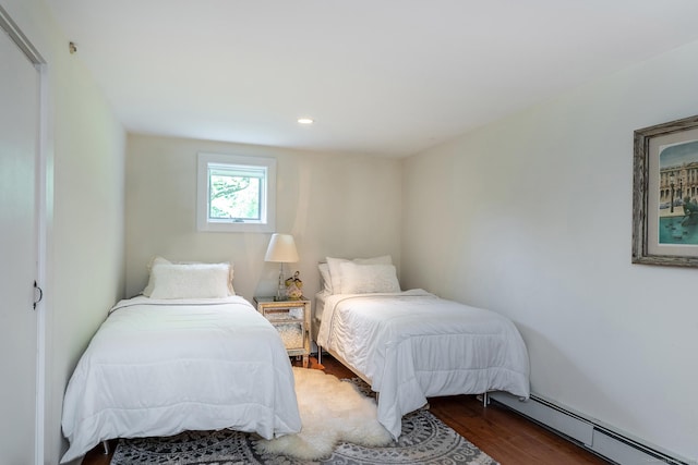 bedroom featuring a baseboard heating unit, wood finished floors, and recessed lighting