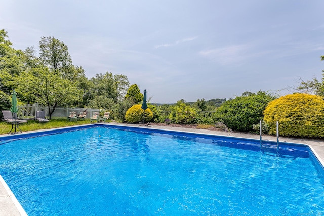 view of pool featuring view of scattered trees