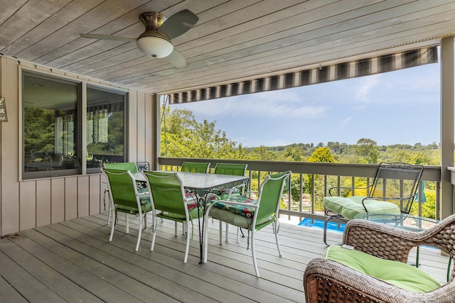 wooden terrace with a ceiling fan and outdoor dining space