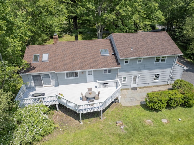 1 Blue Ridge Ln, Wilton, CT 06897 - rear view of house featuring roof with shingles, a deck, a chimney, a yard, and a patio area