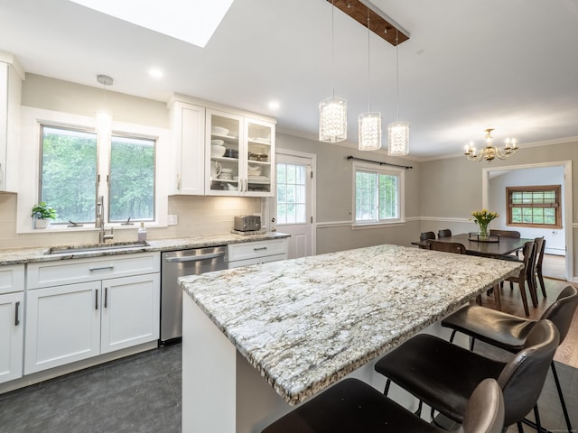 1 Blue Ridge Ln, Wilton, CT 06897 - kitchen with stainless steel dishwasher, a kitchen breakfast bar, white cabinets, pendant lighting, and crown molding