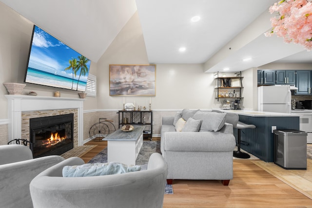 2122 Old Pond Ln Unit 2122, Norwich, CT 06360 - living room with light wood-style flooring, a glass covered fireplace, recessed lighting, vaulted ceiling, and bar area