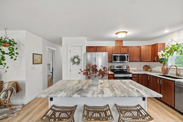 560 Laurel Hill Rd, Norwich, CT 06360 - kitchen with appliances with stainless steel finishes, light wood-style floors, a breakfast bar, and light stone counters