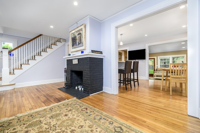 116 Knapp St, Stamford, CT 06907 - living room with light wood finished floors, a brick fireplace, recessed lighting, and stairs