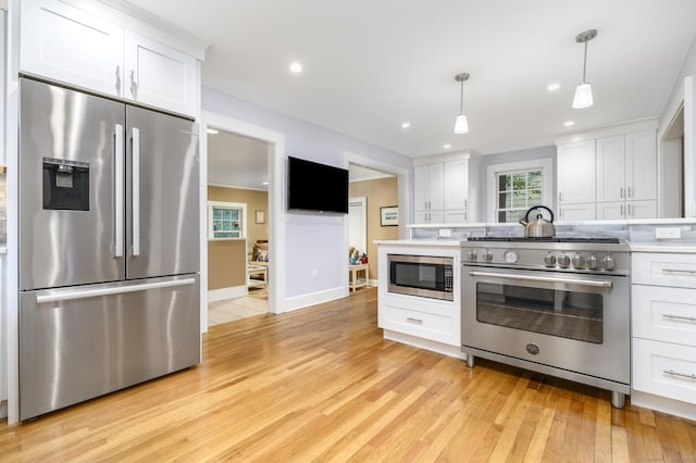 116 Knapp St, Stamford, CT 06907 - kitchen with stainless steel appliances, light wood-style flooring, white cabinetry, hanging light fixtures, and recessed lighting
