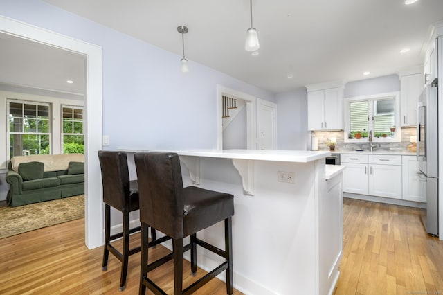 116 Knapp St, Stamford, CT 06907 - kitchen featuring high end fridge, healthy amount of natural light, white cabinetry, and recessed lighting
