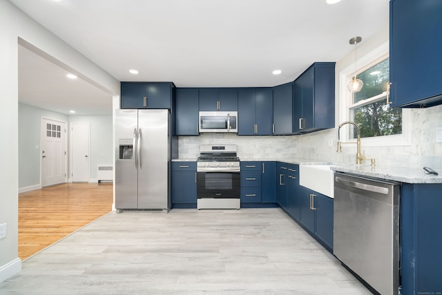 690 Bloomfield Ave, Windsor, CT 06095 - kitchen with stainless steel appliances, blue cabinetry, radiator heating unit, light wood-type flooring, and tasteful backsplash