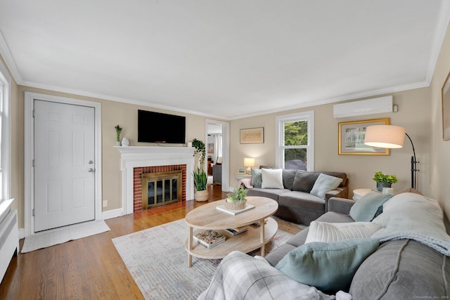 253 Gardner St, Manchester, CT 06040 - living area with a wall mounted air conditioner, a brick fireplace, wood finished floors, and crown molding