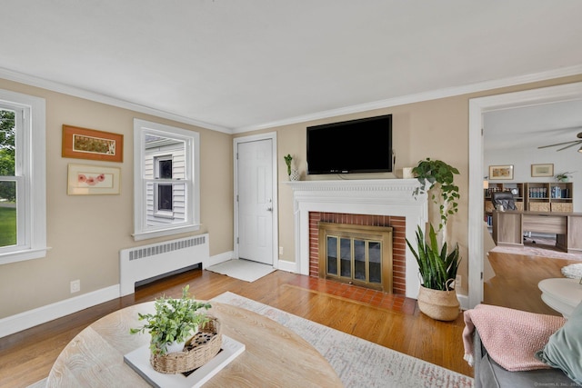 253 Gardner St, Manchester, CT 06040 - living area with radiator heating unit, a brick fireplace, ceiling fan, wood finished floors, and ornamental molding