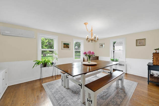 253 Gardner St, Manchester, CT 06040 - dining room with an AC wall unit, radiator, healthy amount of natural light, a chandelier, and wainscoting