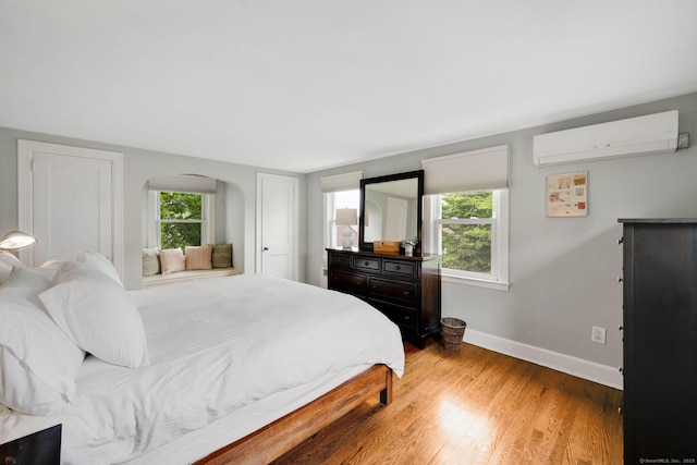 253 Gardner St, Manchester, CT 06040 - bedroom featuring an AC wall unit, light wood-style flooring, and arched walkways