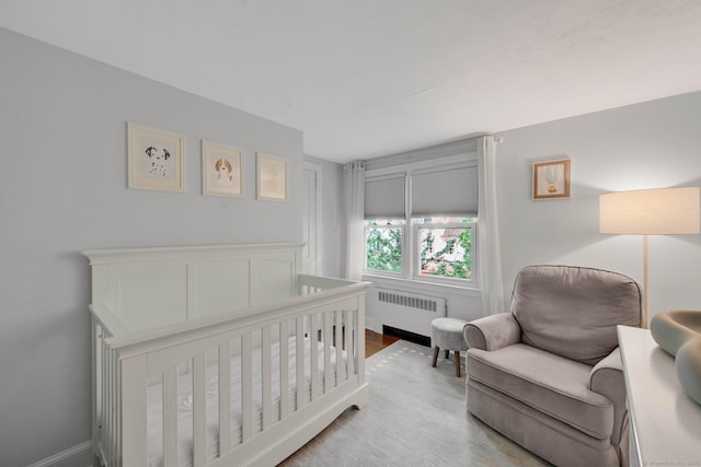 253 Gardner St, Manchester, CT 06040 - bedroom with radiator heating unit, wood finished floors, and a crib