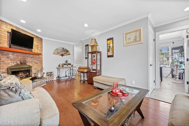145 Arlington St, Bridgeport, CT 06606 - living room featuring a brick fireplace, recessed lighting, crown molding, and wood finished floors